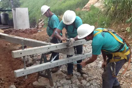 Equipe de campo com equipamentos de segurança montando estruturas de concreto
