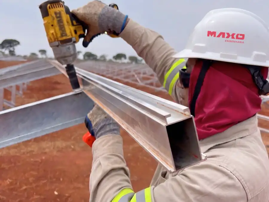 Técnico da Maxo com capacete e uniforme da empresa durante uma obra