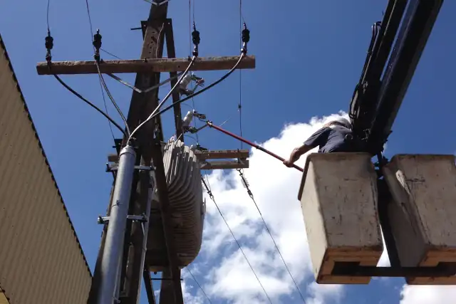 Transformador instalado em poste com caminhão de cesto da equipe ao lado