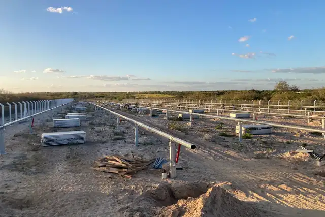 Eixos de rastreadores solares instalados em fileiras no terreno da usina